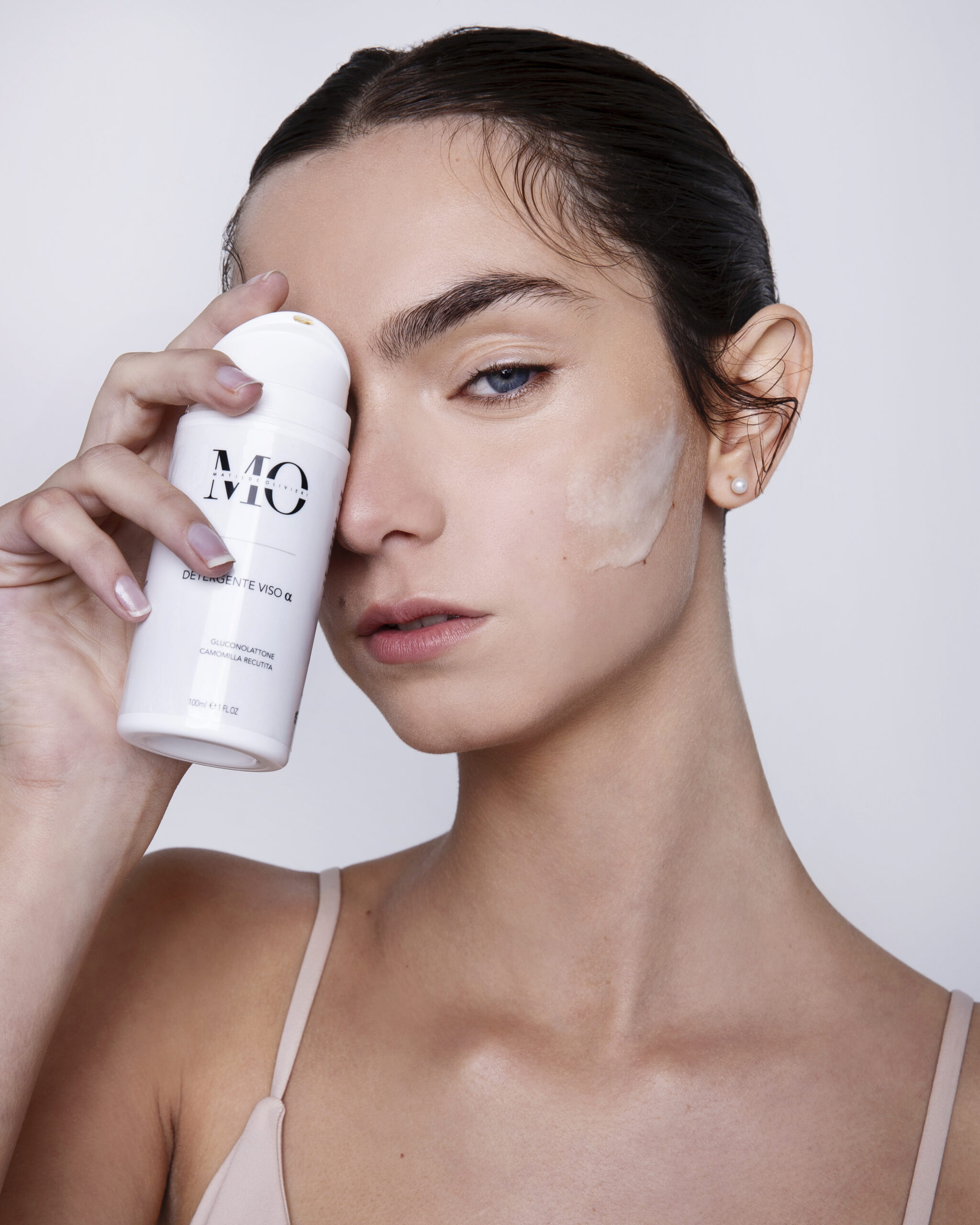 Dettaglio flaconi skincare con packaging elegante e texture luminosa